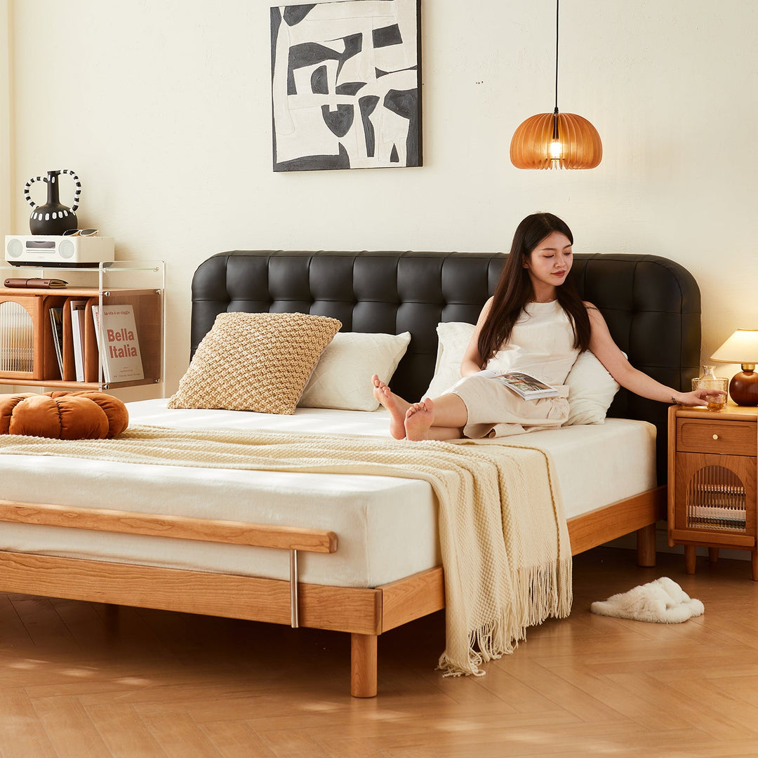 Loft Home top-selling bed frame featuring a sleek black tufted headboard and solid wood base, styled with cozy bedding and a modern bedside table, enhancing contemporary bedroom aesthetics.