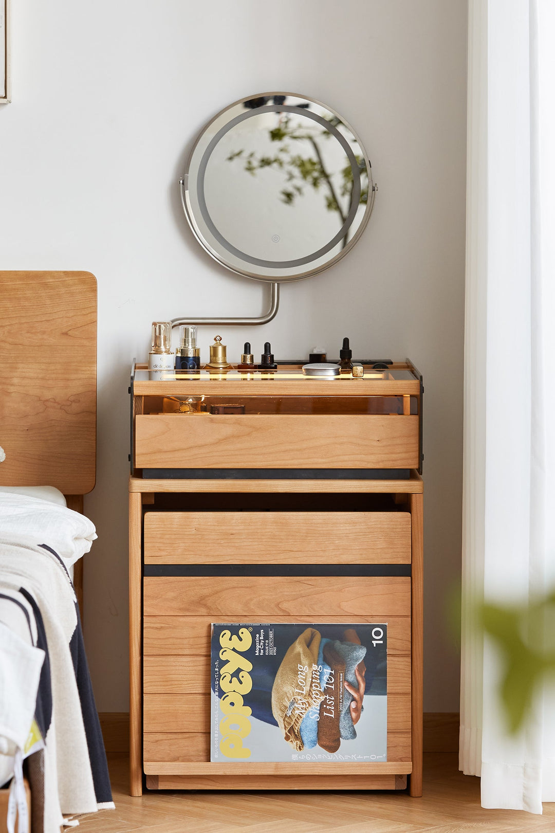 Wooden nightstand with mirror and magazine in a bedroom setting