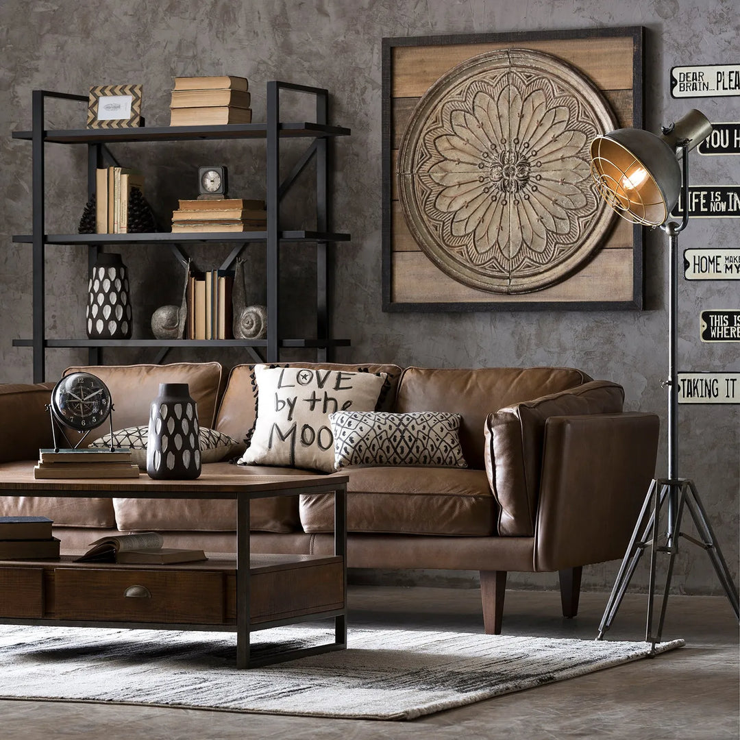 Vintage living room setup with a brown leather sofa, industrial-style coffee table, and decorative shelving, linking to Loft Home's vintage sofas collection.