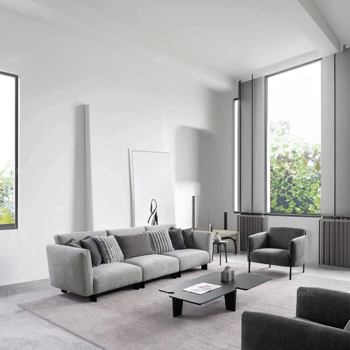 Modern boucle fabric bendable armrest 4 seater sofa pristine in panoramic view.