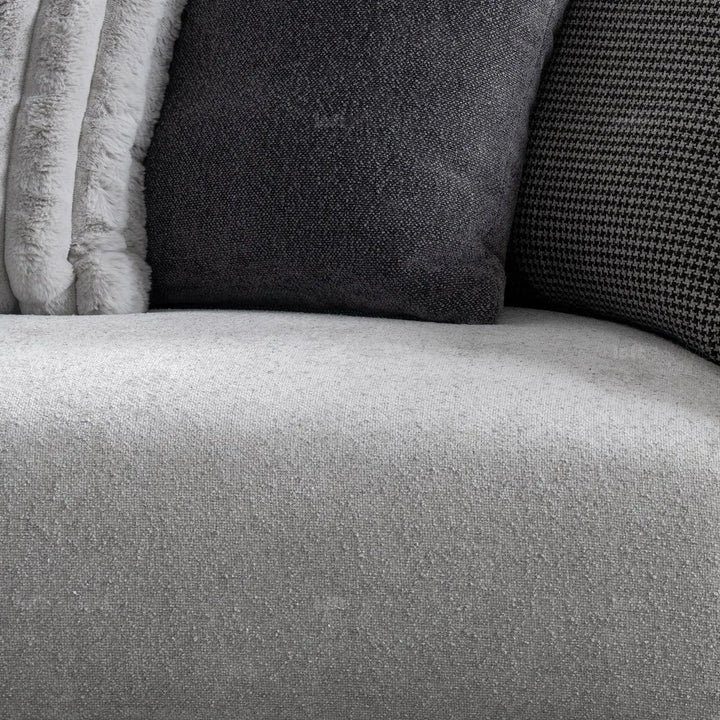 Modern boucle fabric bendable armrest 4 seater sofa pristine in still life.