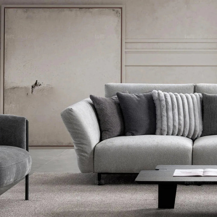 Modern boucle fabric bendable armrest 4 seater sofa pristine in close up details.