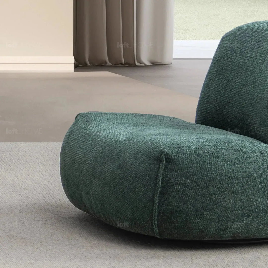 Cream mixed weave fabric revolving 1 seater sofa moss in panoramic view.