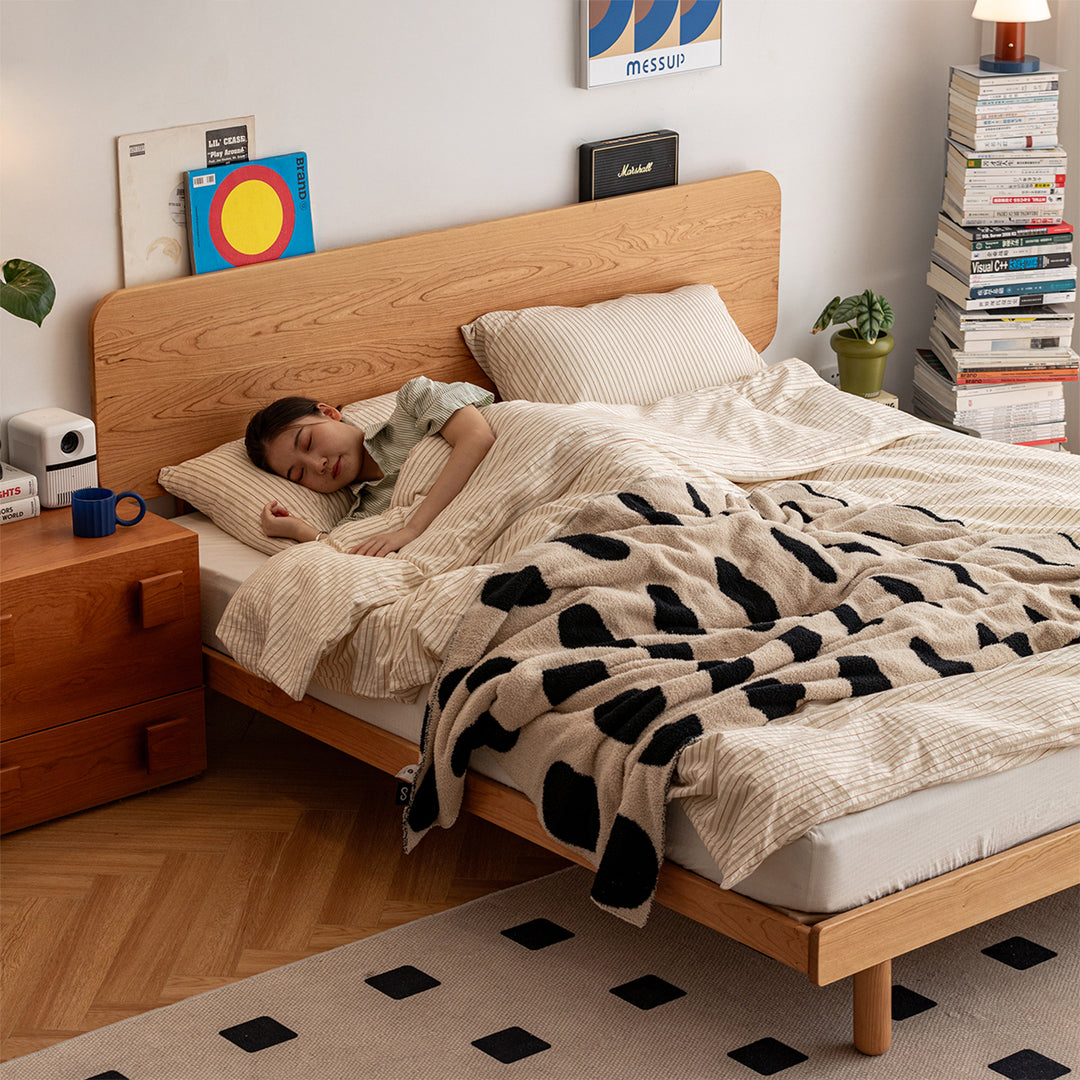 Scandinavian cherry wood bed isle with context.