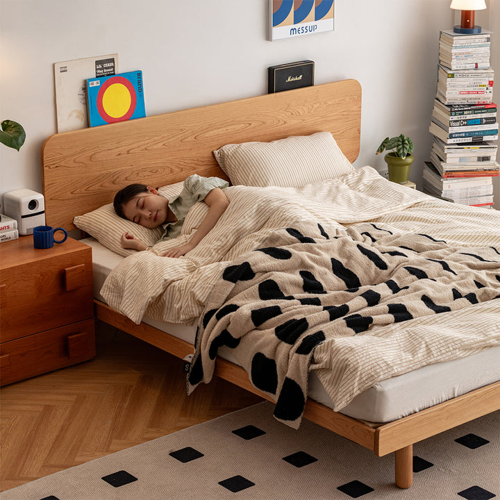 Scandinavian cherry wood bed isle with context.