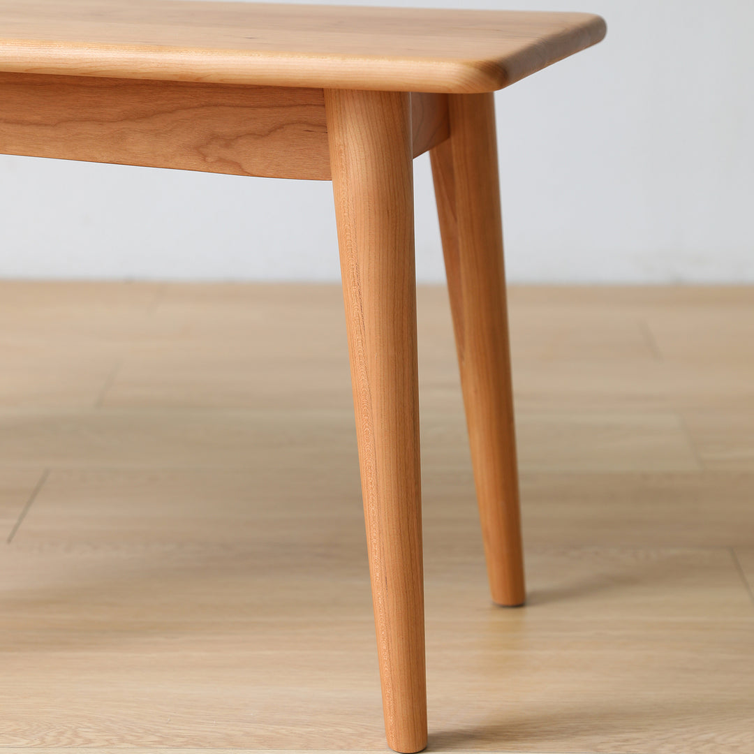 Scandinavian cherry wood dining bench green with context.