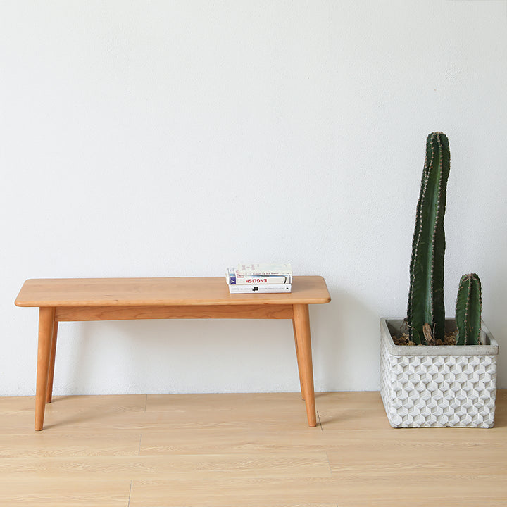 Scandinavian cherry wood dining bench green in close up details.