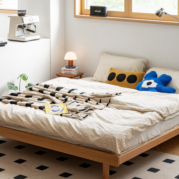 Scandinavian cherry wood platform bed isle in still life.