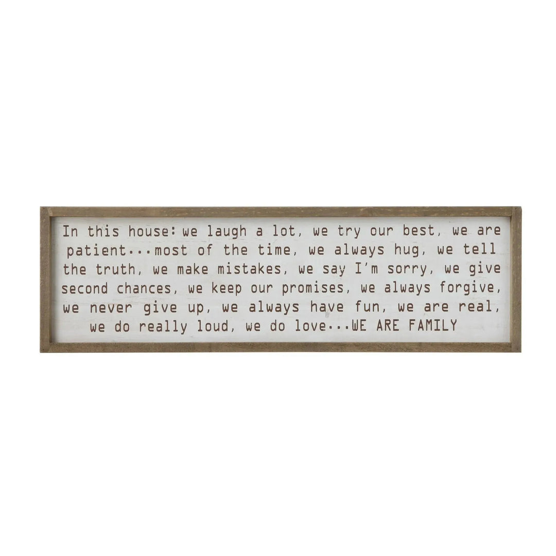 "in this house..." wood framed wall decor in white background.