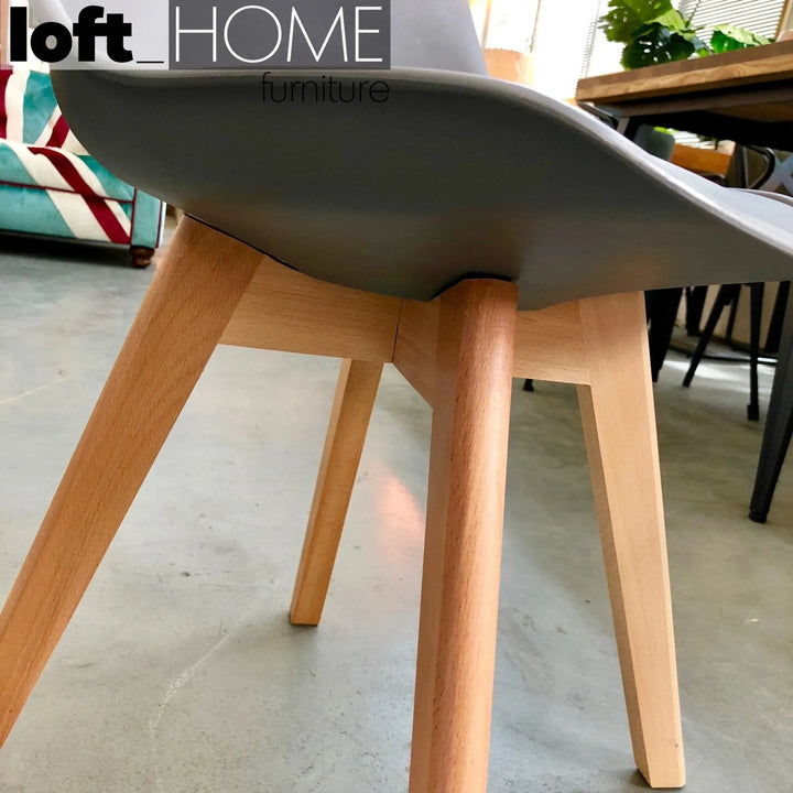 Contemporary plastic dining chair linnet grey with context.