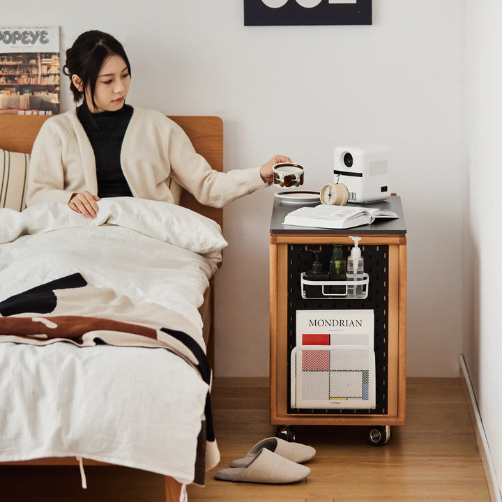 Scandinavian cherry wood wheeled trolley side table bus in still life.