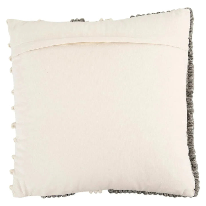 Versatile hand-woven wool looped pillow with context.