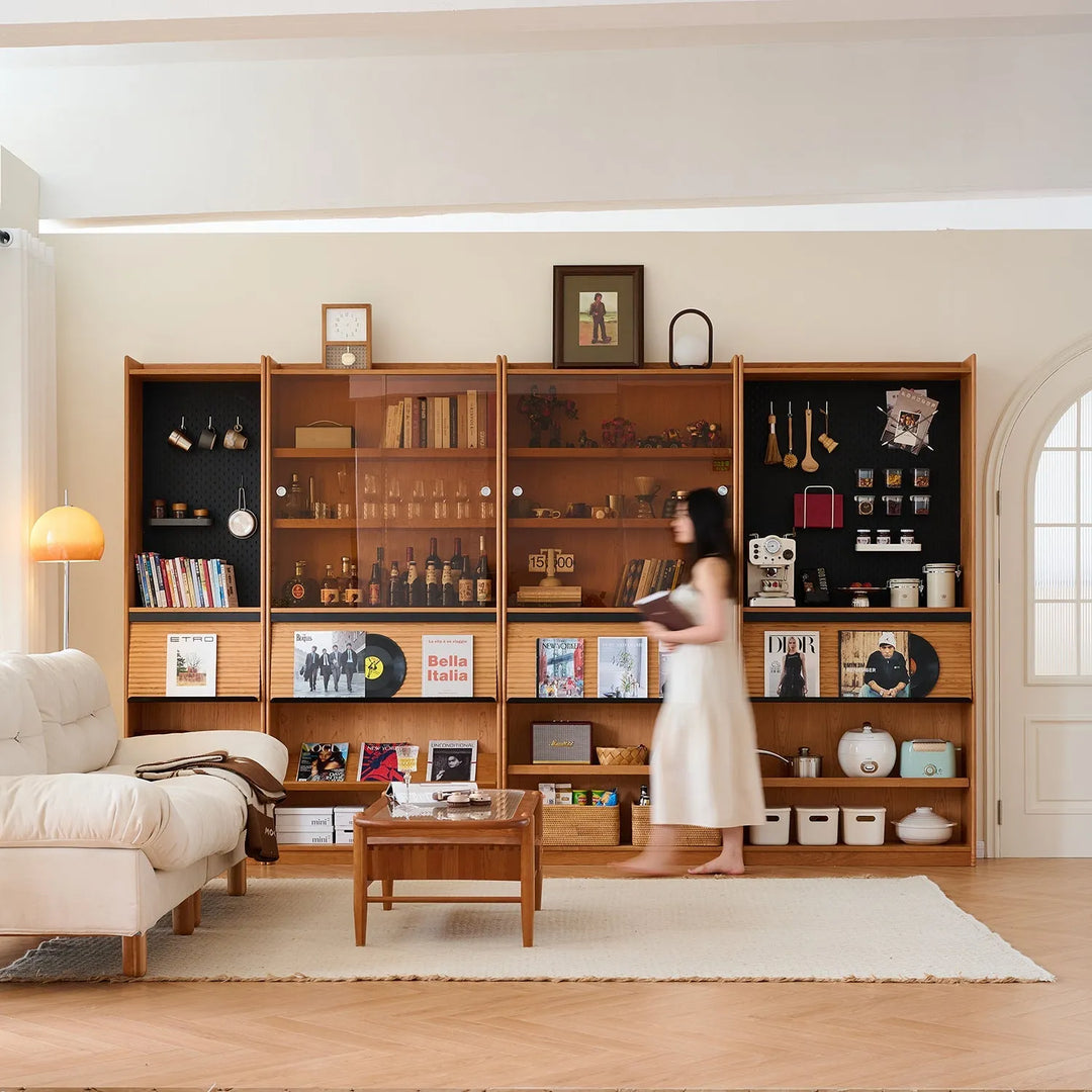 Cozy living room with wooden bookshelves and a green armchair. Explore the bookshelf collection at Loft Home Furniture.