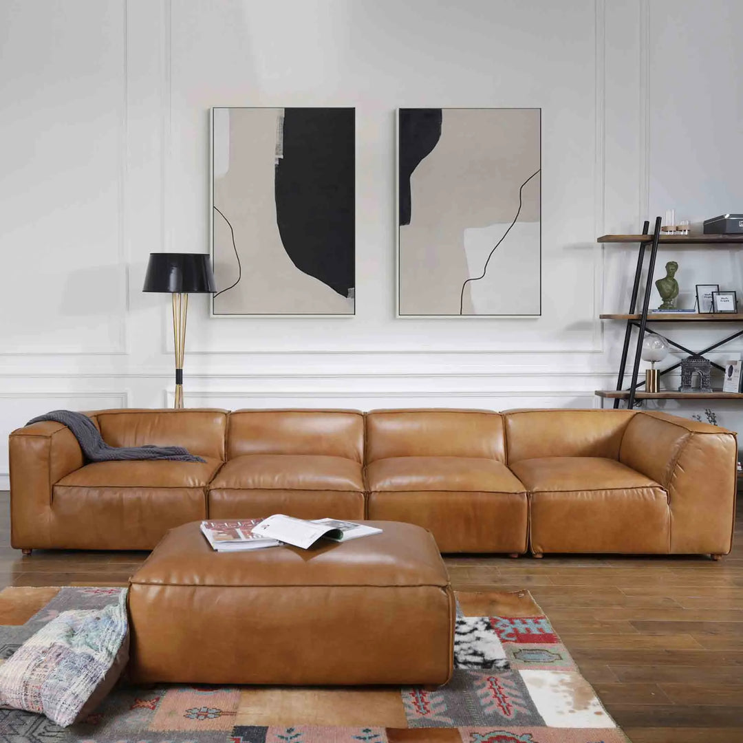 Featured in Loft Home's 4-seater sofa collection: Modern living room with a spacious brown leather 4-seater sofa, matching ottoman, abstract wall art, and contemporary decor.