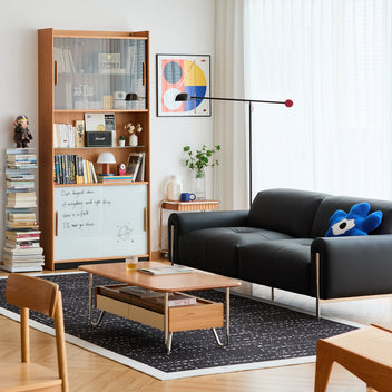 Modern living room setup with black leather sofa, wood coffee table, and display cabinet, featuring Loft Home’s curated space styling inspirations for every room.