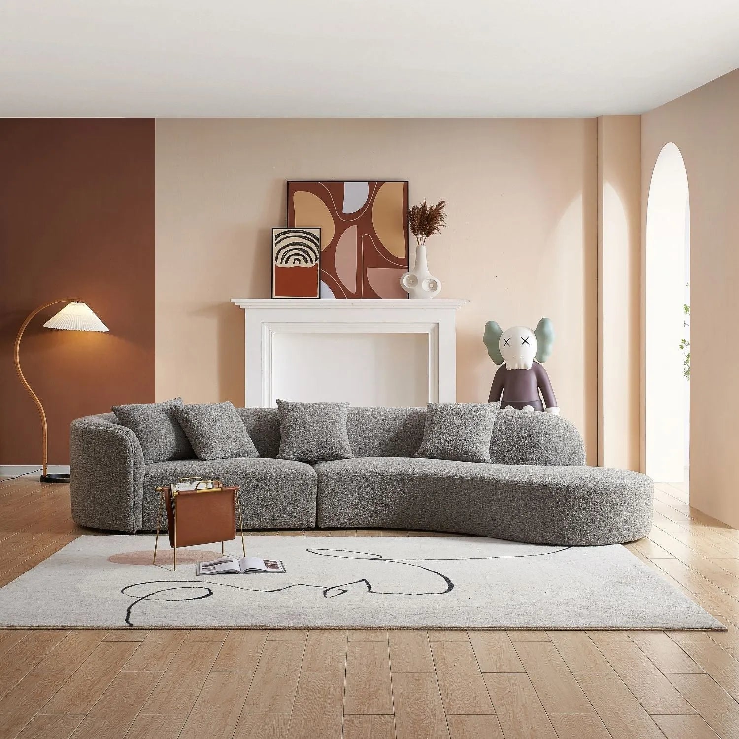 Modern living room with a grey curved sectional sofa and contemporary art. Explore our sofas at Loft Home Furniture.