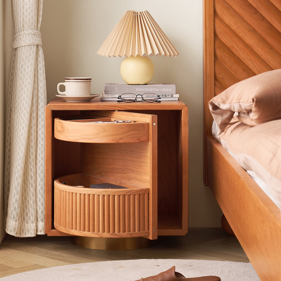 Modern wooden side table with a sliding drawer and fluted panel design, paired with a lamp and books, perfect for cozy bedroom aesthetics.