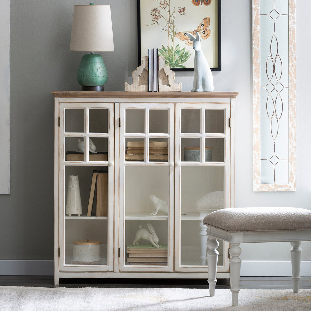 Loft Home vintage-style glass-front cabinet with distressed white finish, ideal for showcasing books and decor in classic interiors.