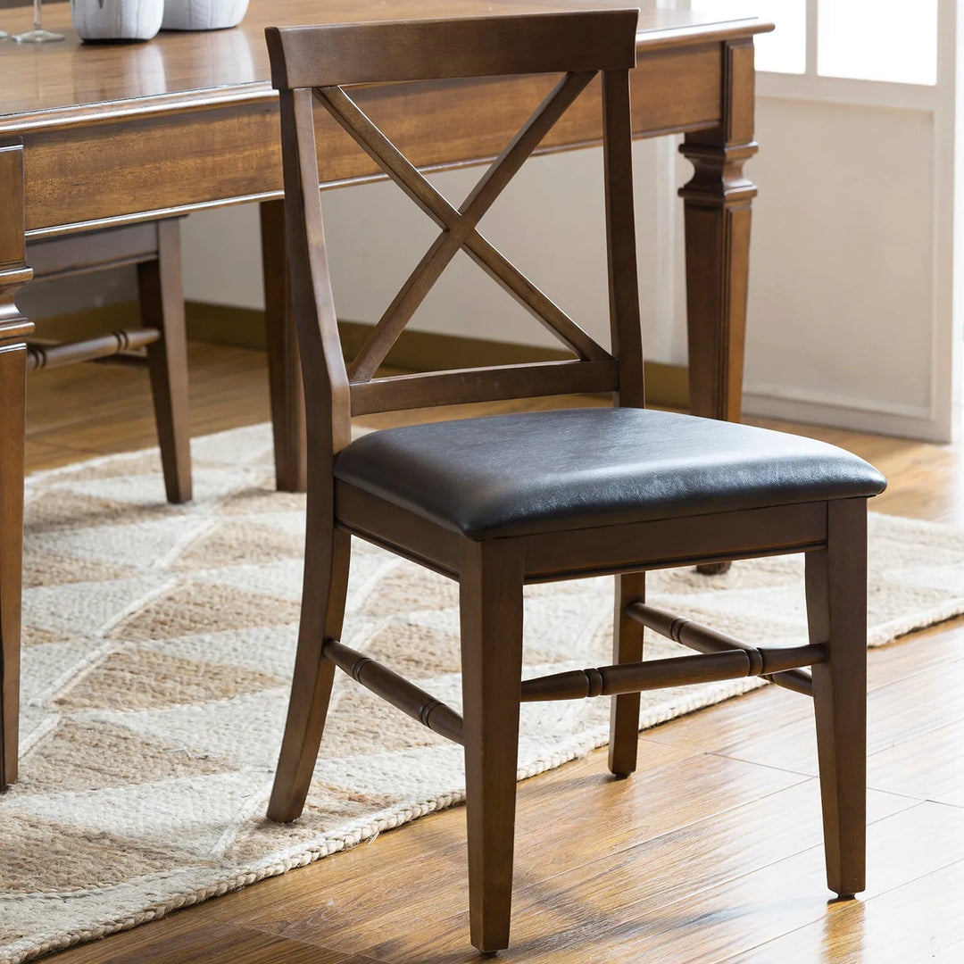 Classic wooden dining chair with an X-back design and cushioned seat, placed next to a matching dining table, linking to Loft Home's chairs by type collection.