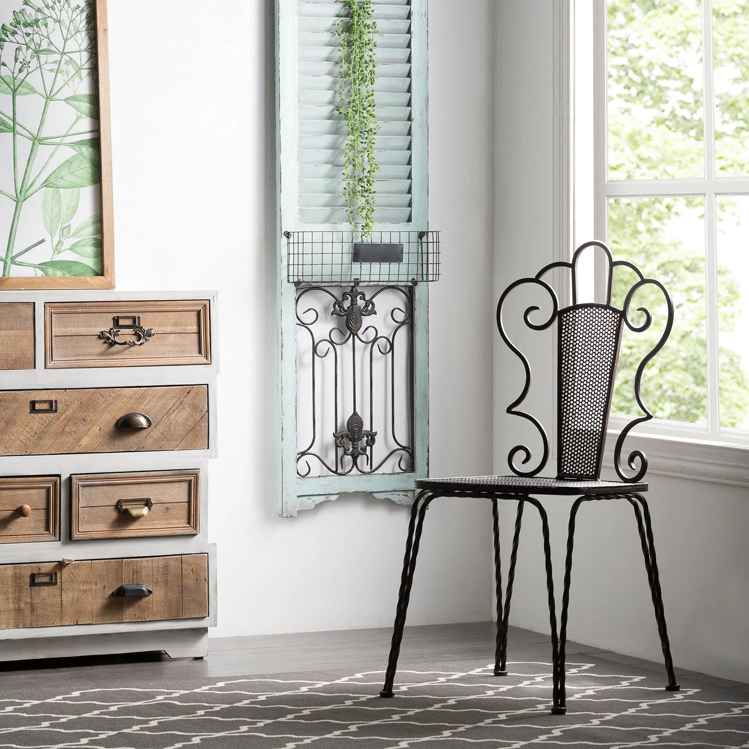 Eclectic living space featuring a decorative metal chair, a rustic wooden dresser, and vintage wall decor, linking to Loft Home's chairs by material collection.