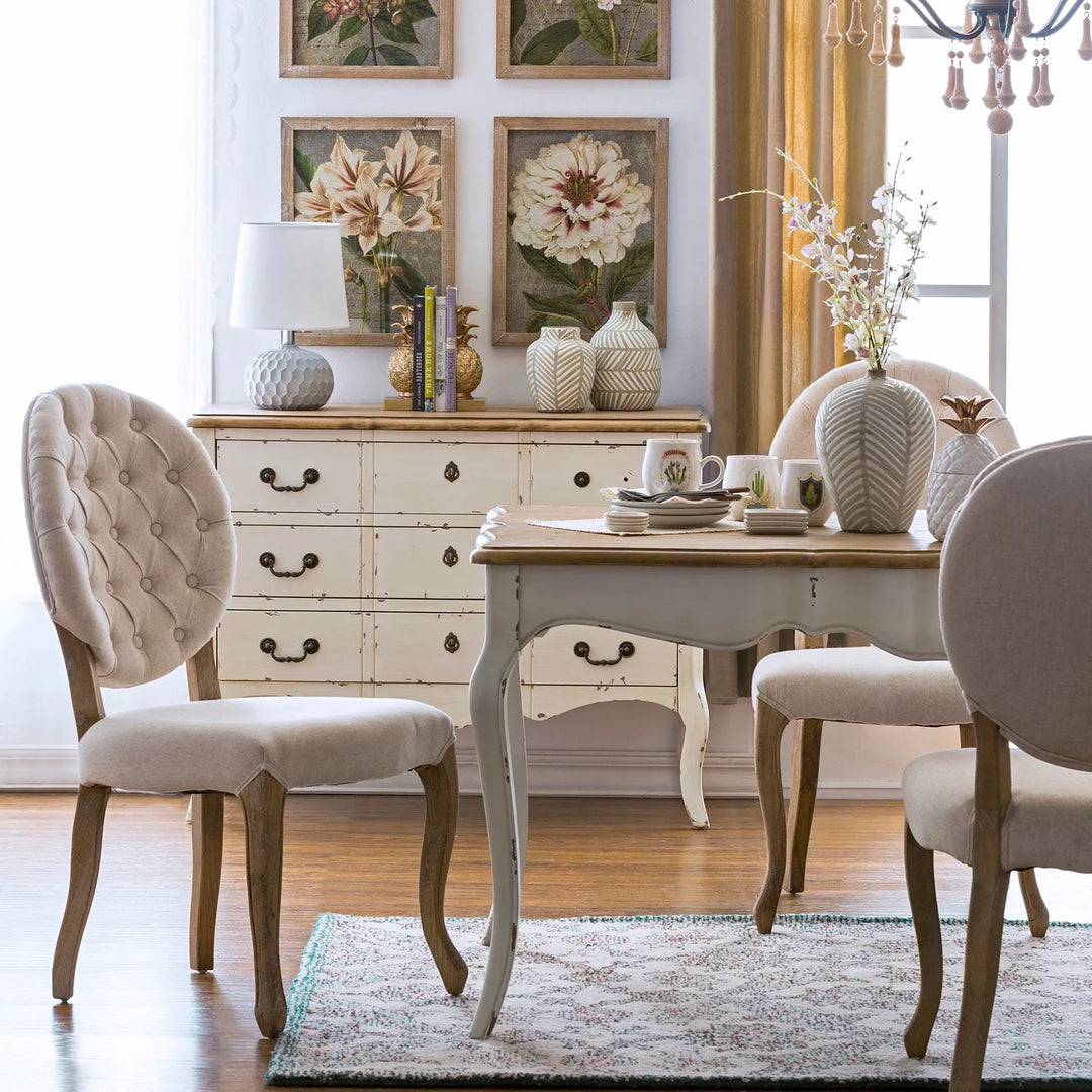 Elegant dining room featuring tufted upholstered chairs, a vintage wooden table, and classic floral decor, linking to Loft Home's chairs by style collection.