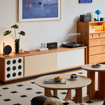 Scandinavian-style living room with minimalist wood furniture, record player, and modern decor, showcasing LOFT HOME’s cozy and functional interior setup.