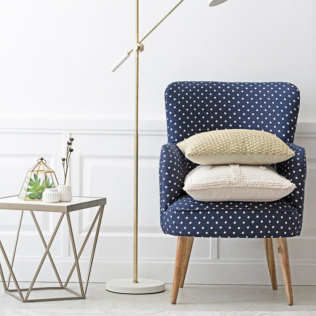 Loft Home stylish living room featuring a blue polka dot accent chair with decorative cushions, a modern side table, and minimalist decor.