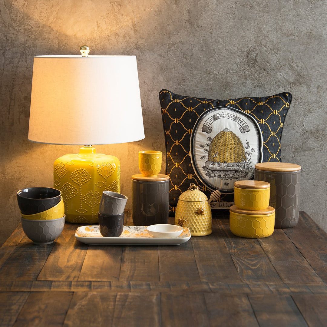 Loft Home decor collection featuring a vibrant yellow honeycomb lamp, bee-themed pillows, and matching ceramic jars, perfect for cozy and stylish interiors.