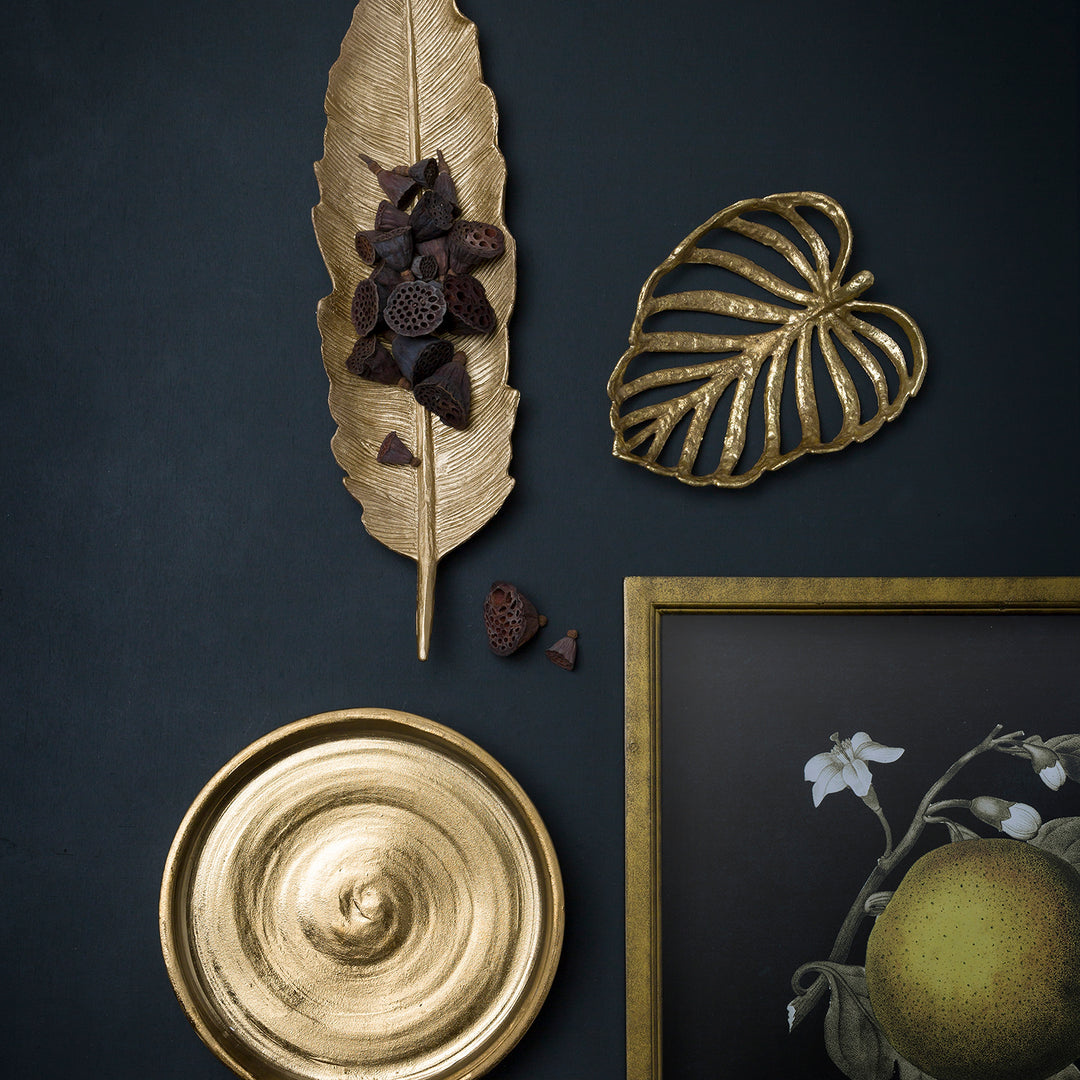 Loft Home decorative gold accents featuring a leaf tray, abstract designs, and artistic elements for a modern and elegant display.