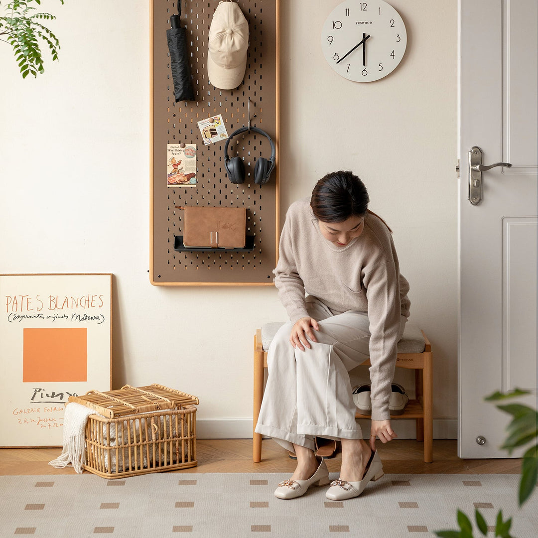 Minimalist entryway bench with a cushioned seat and natural wood frame, offering functional seating and storage for organizing daily essentials.