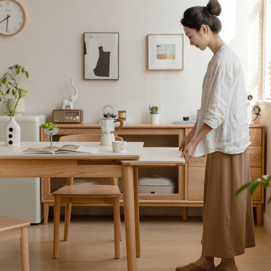 Loft Home extendable dining table collection, showcasing a sleek oak wood table with a foldable design, paired with minimalist chairs, styled in a bright and cozy dining room for versatile and modern dining solutions.