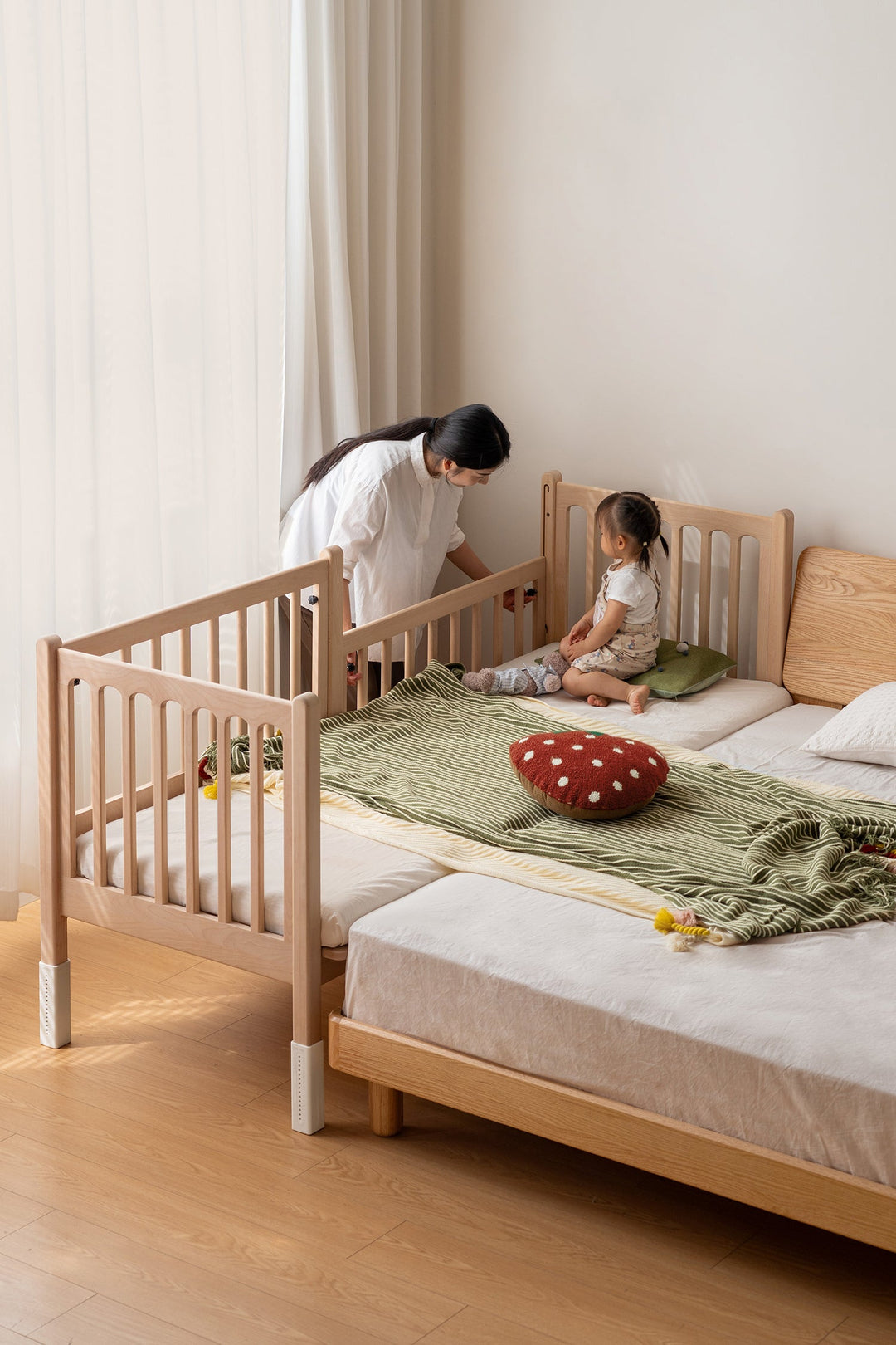 Loft Home wooden sidecar bed frame with safety rails, styled with soft bedding, enhancing a safe and cozy family sleeping space.