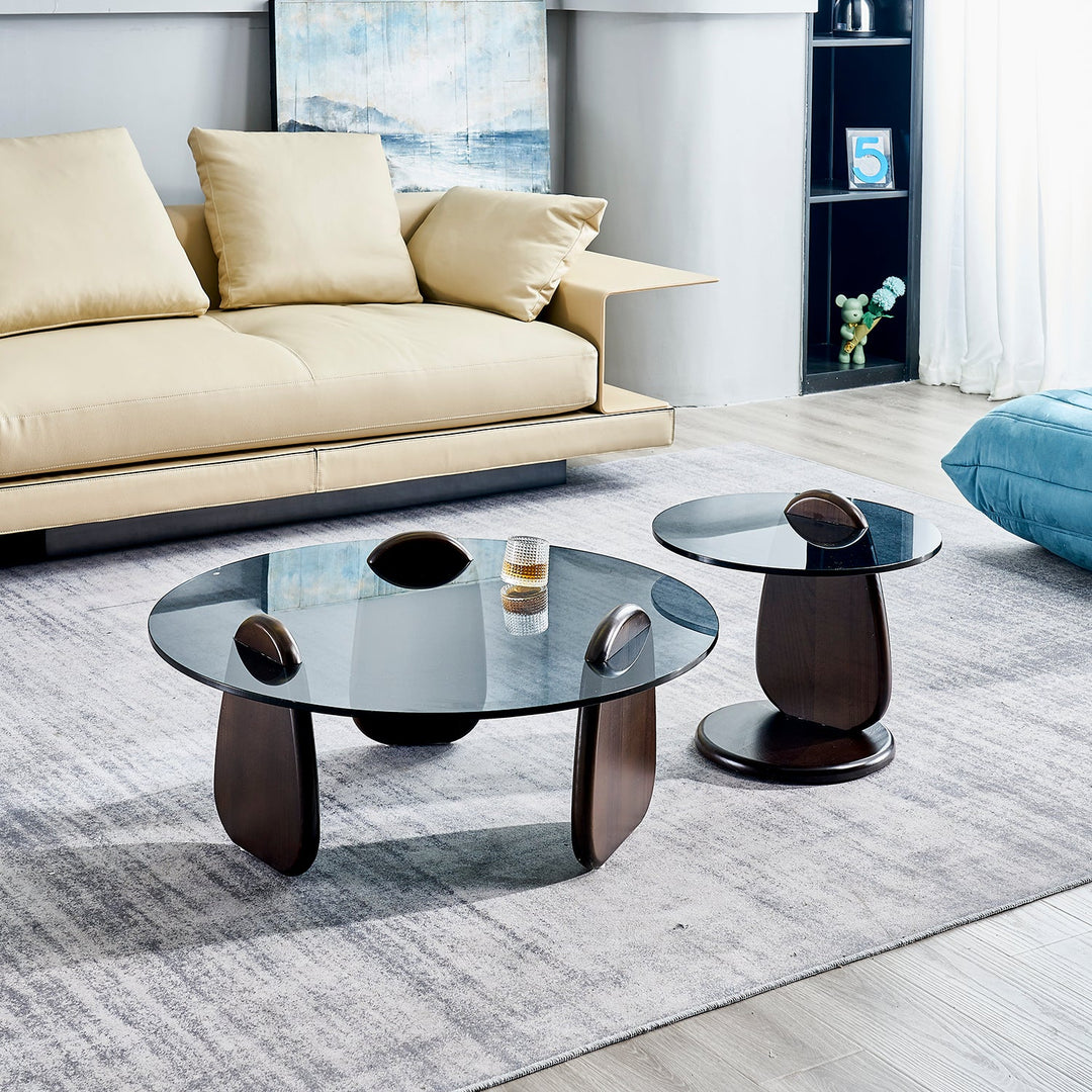 Elegant round glass coffee table with sleek wooden base, blending modern aesthetics with functional design to enhance contemporary living rooms.