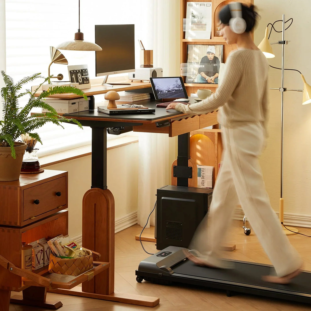 Height adjustable desk paired with a treadmill and cozy workspace setup, featuring wooden storage units and modern decor, enhancing productivity and ergonomic comfort.