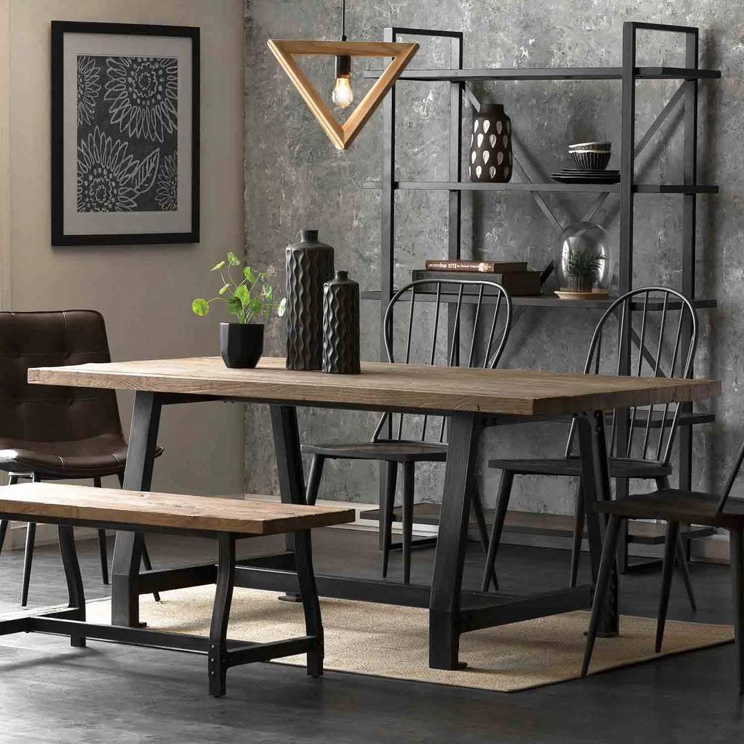 Featured in Loft Home's 4-8 seater tables collection: Industrial-style dining area with a large wooden table, matching bench and chairs, geometric pendant light, and modern decor.