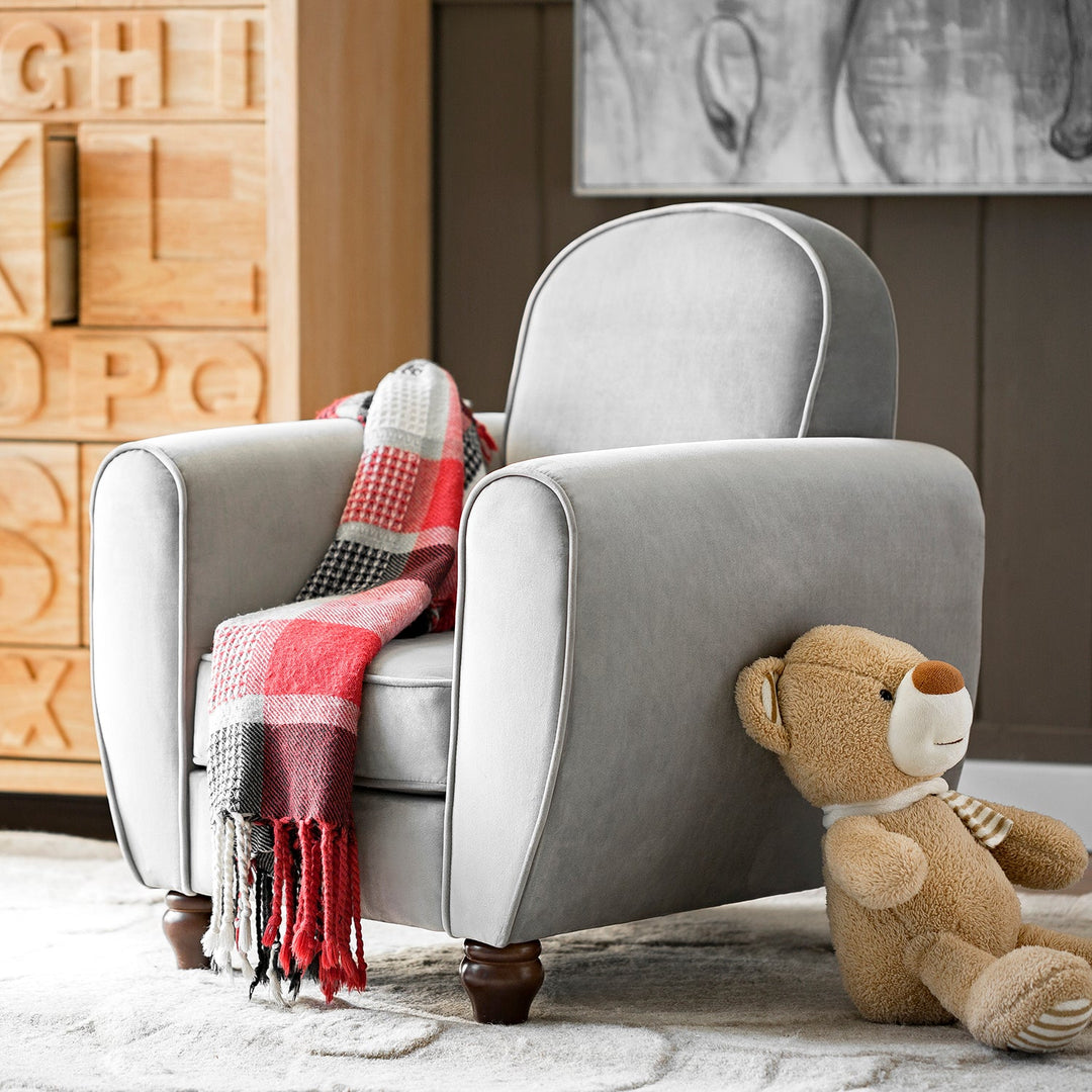 Loft Home kids’ room sofa in soft grey upholstery, styled with a cozy red and white plaid blanket and a plush teddy bear.