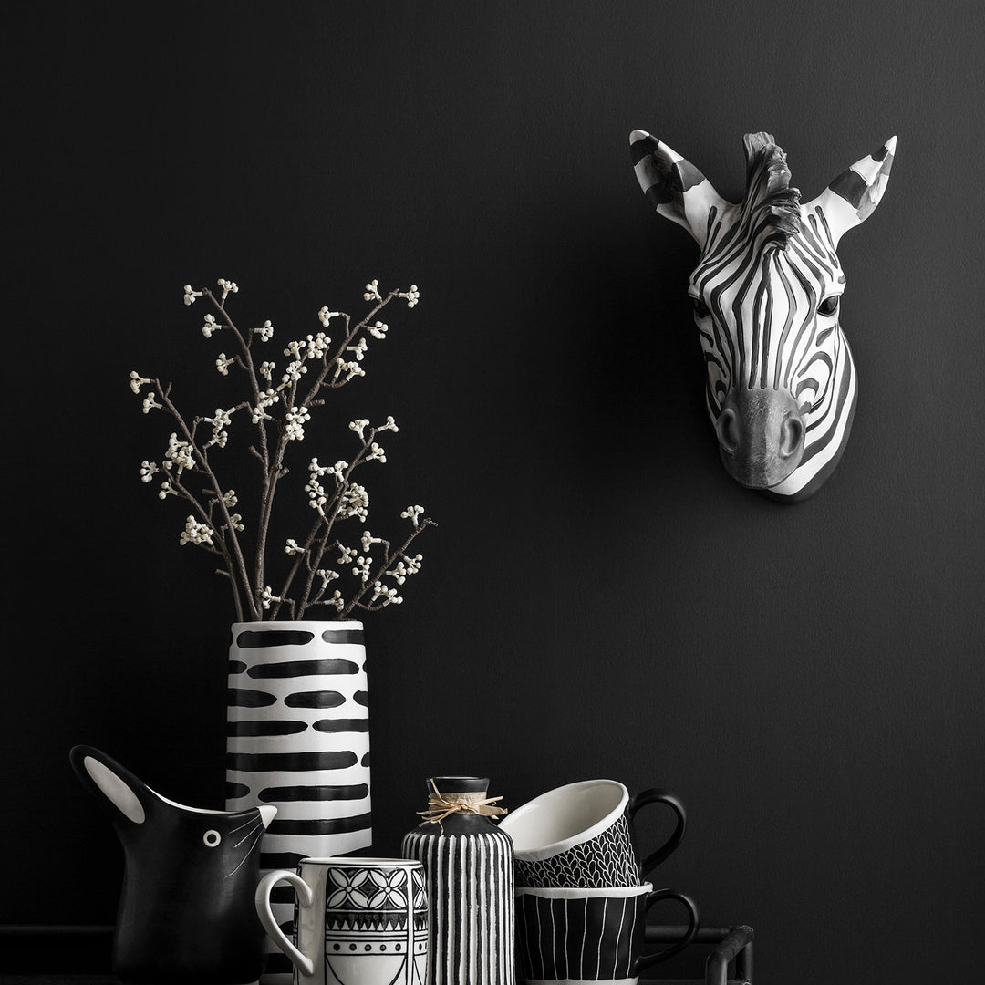 Loft Home black and white zebra-themed decor featuring ceramic vases, mugs, and a zebra wall ornament for a modern, bold statement piece.