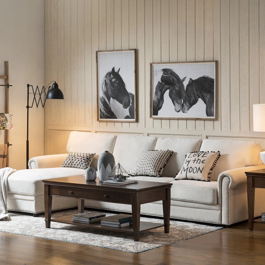 Featured in Loft Home's living room collection: Elegant living room with a cream L-shaped sofa, dark wood coffee table, decorative pillows, horse-themed wall art, and cozy lighting.