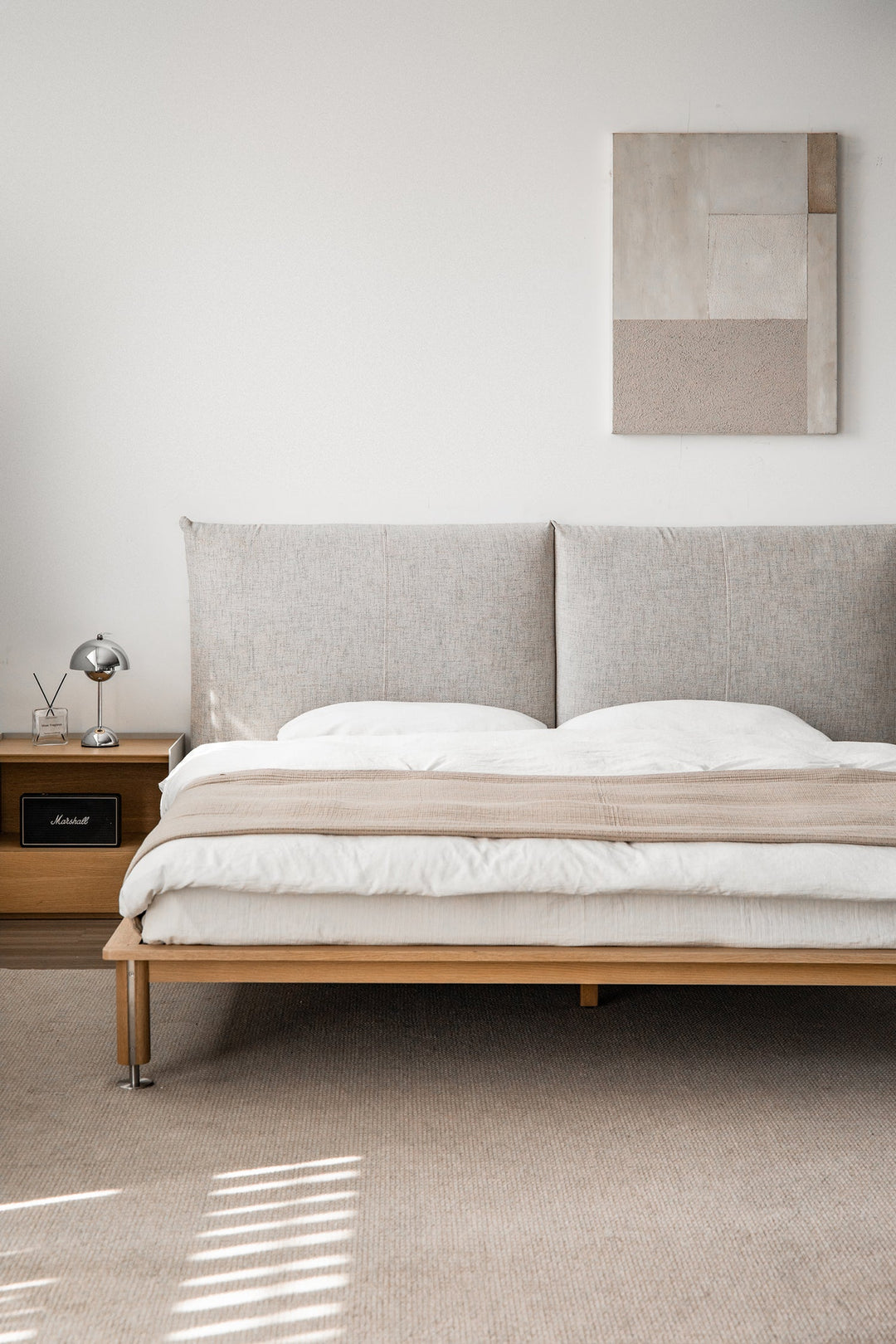 Minimalist premium fabric bed frame in soft neutral tones, sleek wooden base, styled for calm modern bedrooms and elevated comfort in Singapore homes.