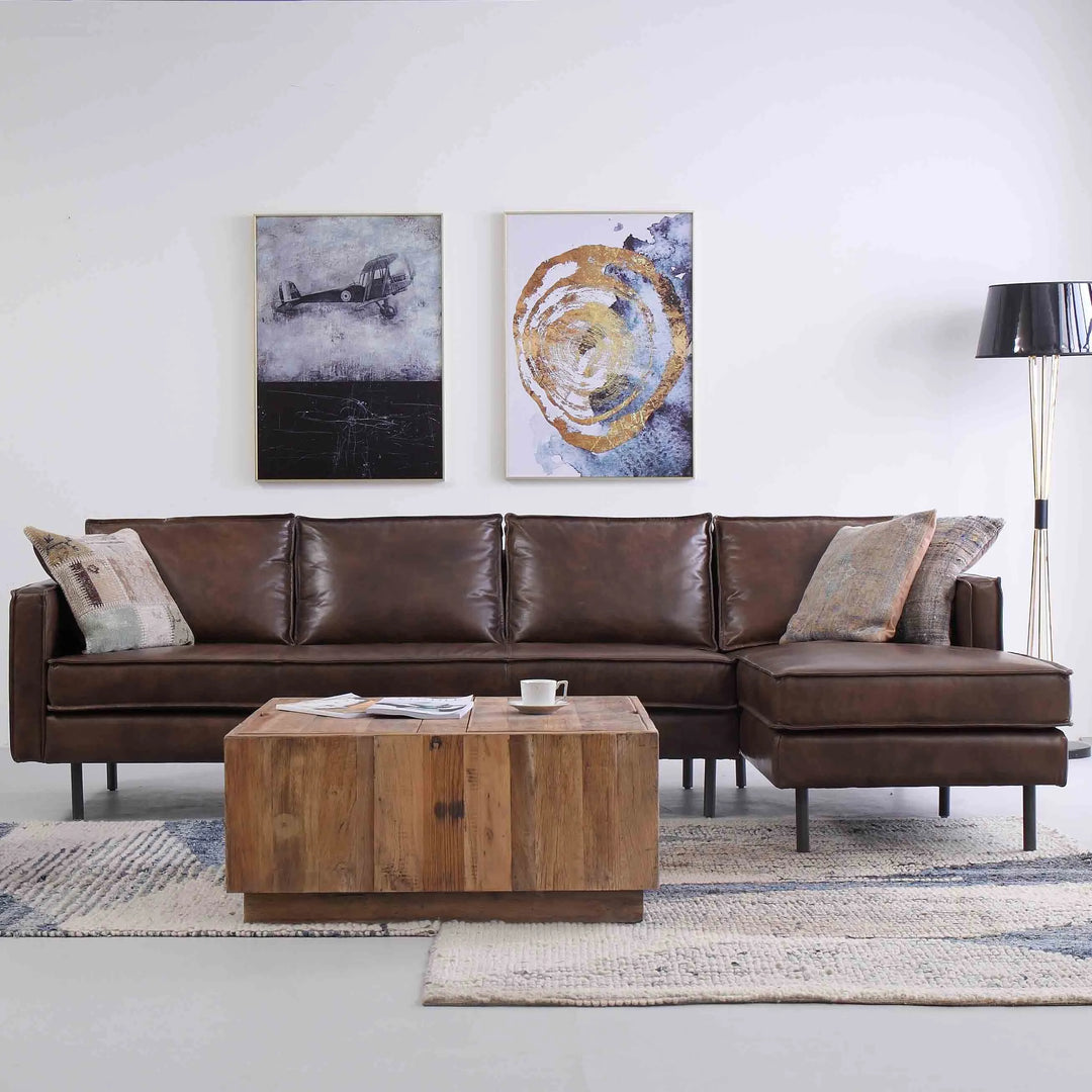 Featured in Loft Home's L-shape sofa collection: Contemporary living room with a brown leather L-shaped sofa, wooden coffee table, abstract wall art, and modern decor.