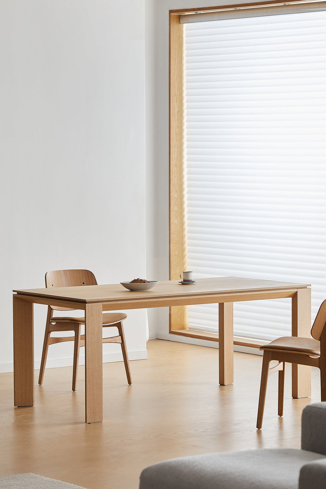 Minimalist premium wooden dining table styled in a bright modern interior, clean lines bringing warm elegance and functional design to Singapore homes.