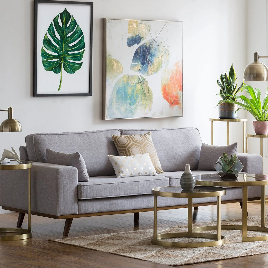 Minimalist living room with a grey sofa, modern side tables, and colorful abstract wall art, linking to Loft Home's minimalist sofas collection.