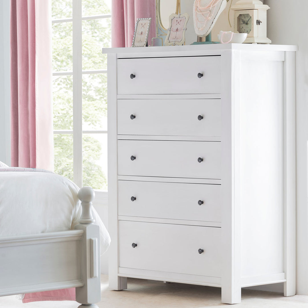 Loft Home Modern Storages – Sleek white dresser with black knobs, complemented by soft pink curtains, enhancing elegant and functional bedroom decor.