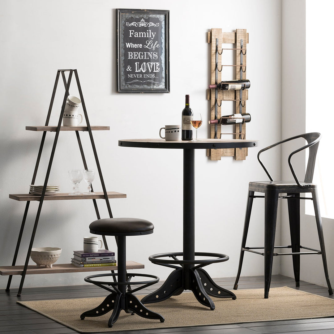 Round bar table with a sleek black finish, paired with matching stools, creating a cozy and modern corner for wine and conversation in a contemporary home.