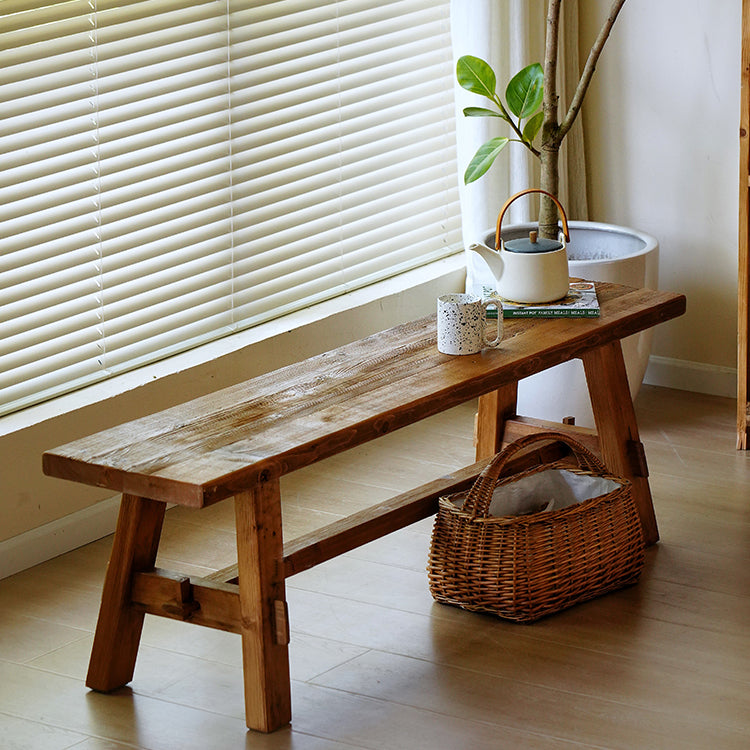 Rustic wooden bench with a natural distressed finish, complemented by a sturdy frame, perfect for adding charm and warmth to any space.