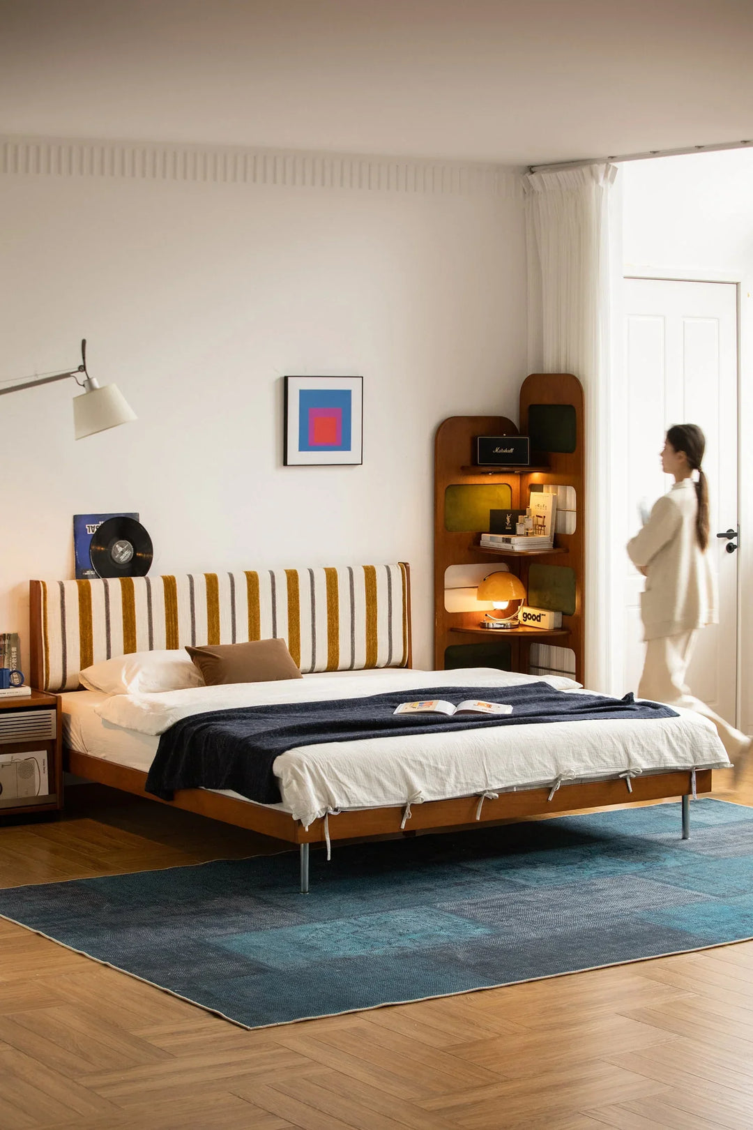 Modern wooden bed with striped upholstered headboard, styled in a warm contemporary bedroom, offering restful comfort for Singapore homes.