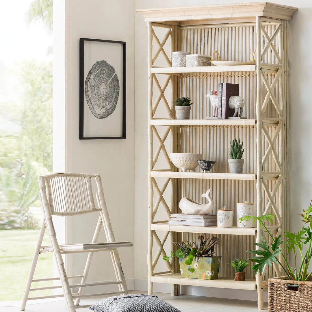 "Light and airy room featuring a tall wooden shelving unit with decorative items, a matching wooden chair, and botanical decor, linking to Loft Home's shelves collection.