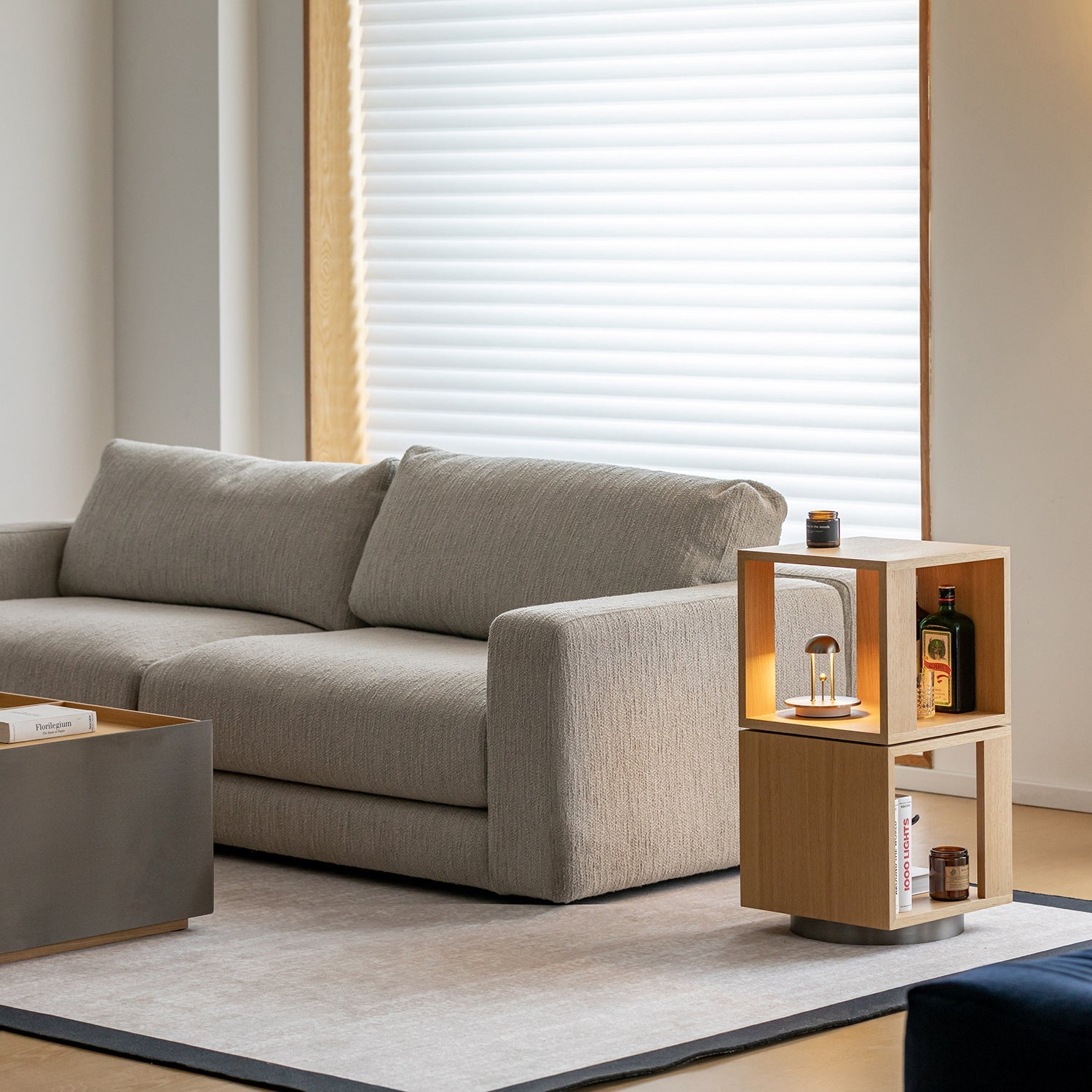 Person styled against a natural wood furniture panel, representing Loft Home’s material collections designed to suit modern living spaces.