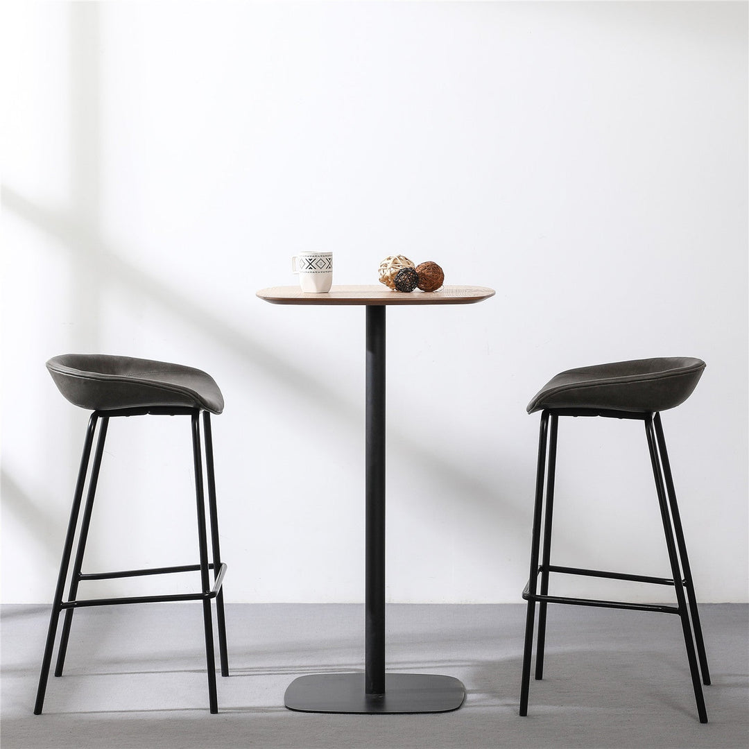 Compact bar table with a minimalist design, featuring a sleek black metal base and a wooden tabletop, ideal for cozy dining or small spaces.