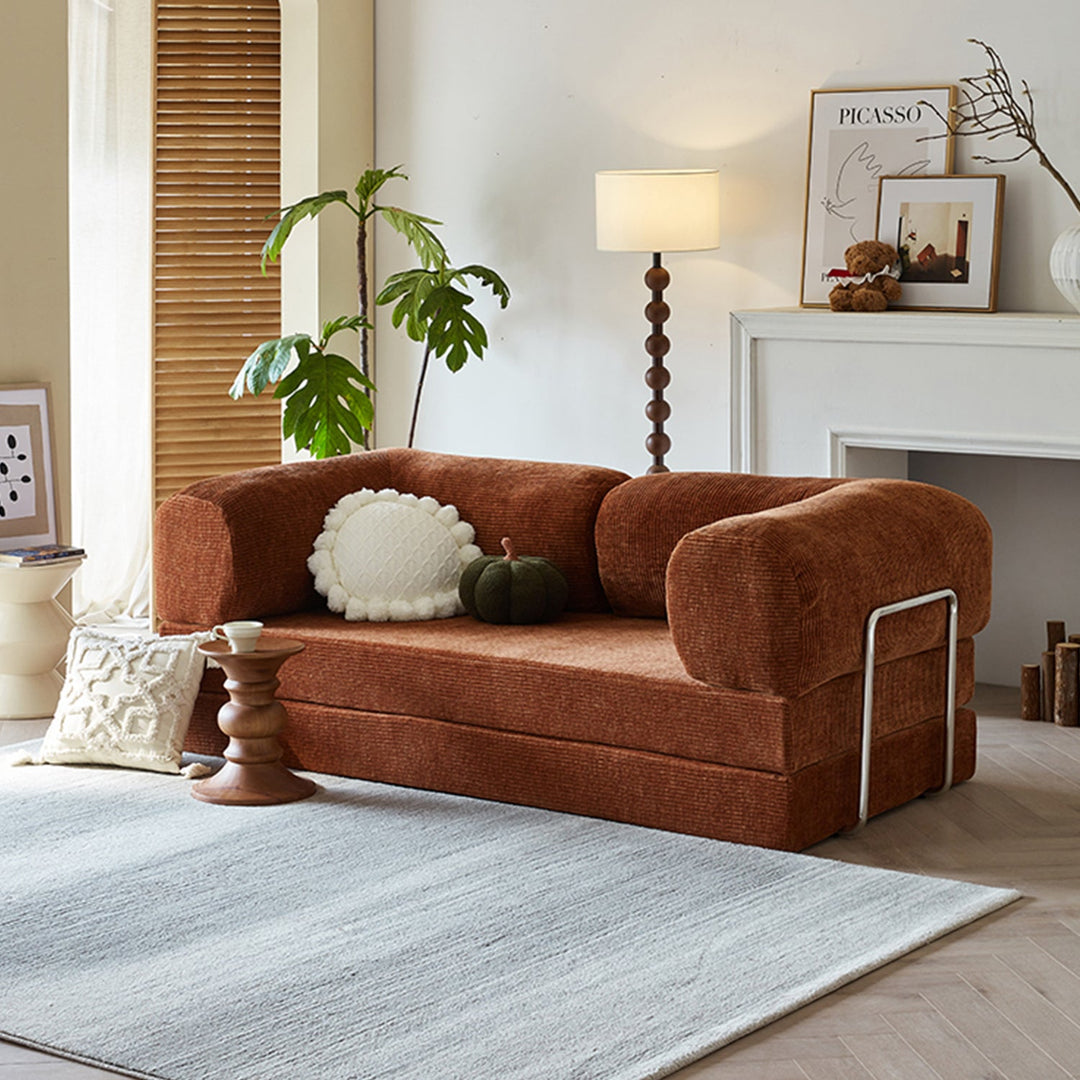 Loft Home small sofa bed collection, featuring a compact rust-colored fabric sofa bed with rounded armrests and a foldable design, ideal for cozy living spaces and multifunctional comfort.